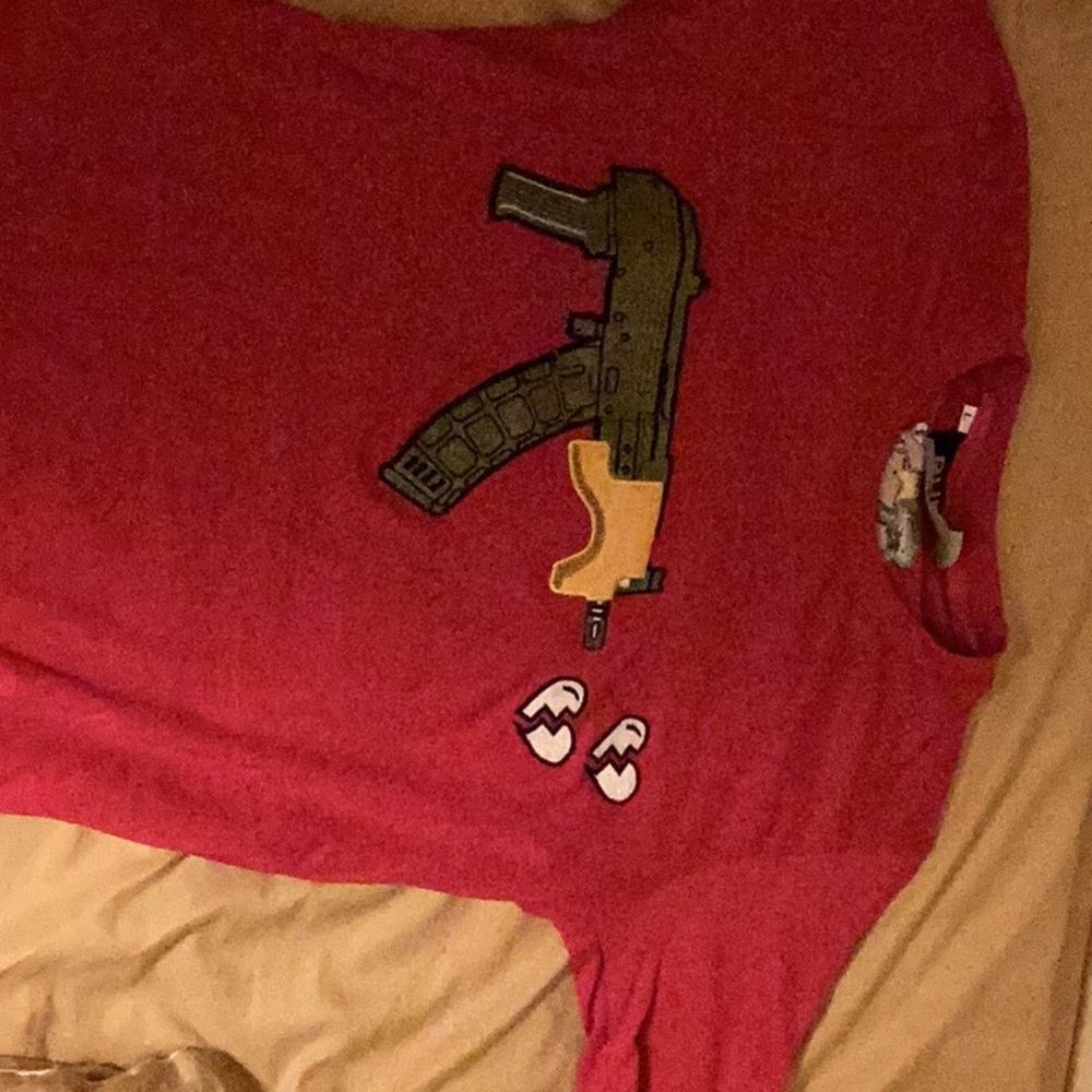 selling pink shirt with gun on it